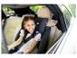 Fille souriante dans un siège auto pour enfant sur la banquette arrière d'une voiture.