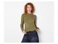 Vrouw draagt een olijfgroene geribbelde top met lange mouwen en een donkere jeans.