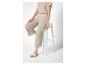 Beige top en wijde pantalon, gevlochten sandalen.