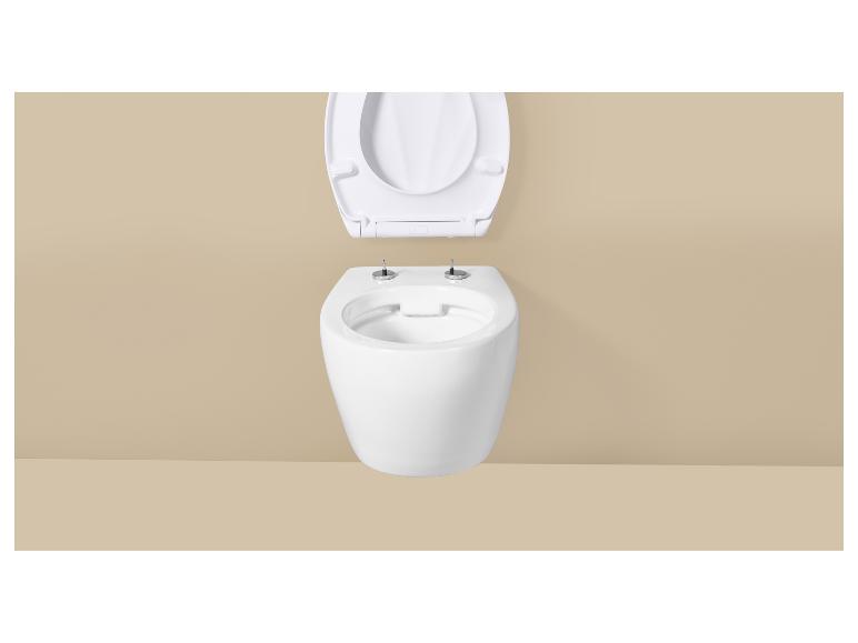 Toilettes murales blanches avec couvercle ouvert sur un mur beige.