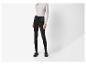 Vrouw in zwarte legging en lichtgrijze top met lange mouwen