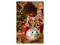 Kind speelt met een pluchen discobal naast een kerstboom.