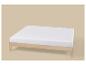Wit matras op een licht houten bedframe tegen een beige achtergrond.