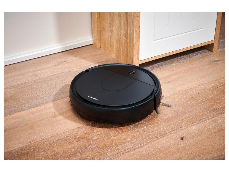 SilverCrest robotstofzuiger op een houten vloer naast een witte kast