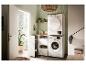 Moderne wasruimte met wasmachine, droger, kasten en planken.