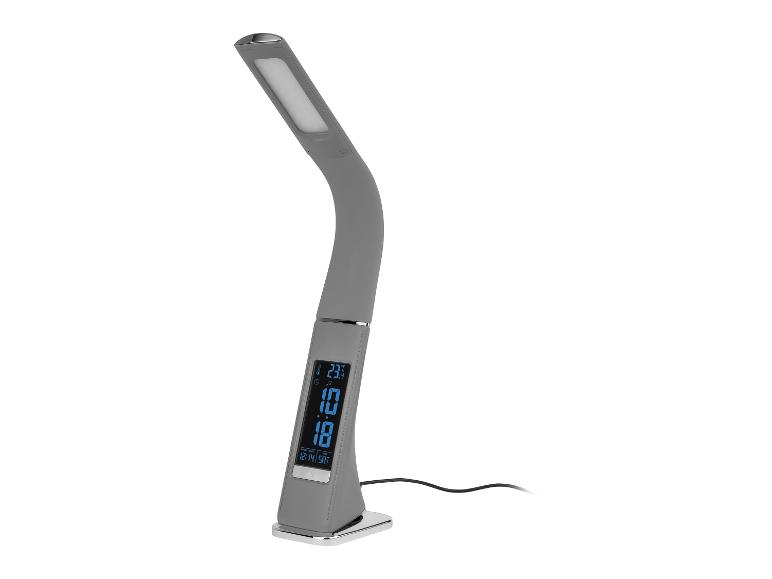 Een grijze bureaulamp met een digitaal display dat de tijd, datum en temperatuur toont.