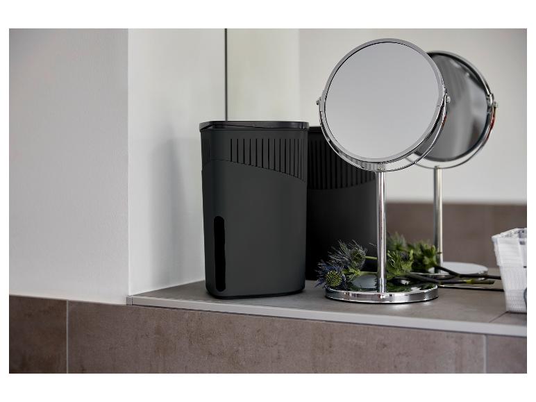 Un déshumidificateur noir et un miroir de table dans une salle de bain moderne.