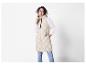 Vrouw in een beige gewatteerd vest met capuchon.