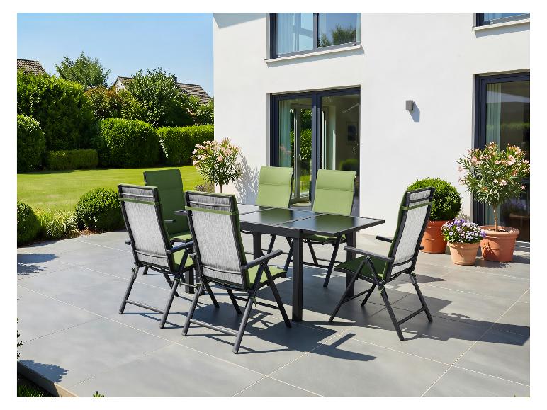 Ensemble de salle à manger d'extérieur avec table noire et six chaises vertes et grises sur une terrasse.