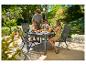 Une famille prend son petit-déjeuner sur la terrasse avec une table et des chaises de jardin.