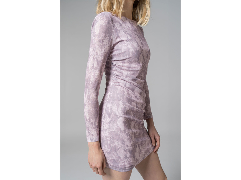 Une femme porte une robe rose à imprimé serpent.