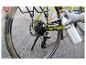 Gehandschoende hand smeert fietsketting met Parkside spray.