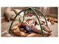 Baby op speelmat met speelboog en hangende speeltjes.