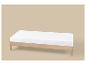 Houten bed met wit matras op beige achtergrond.