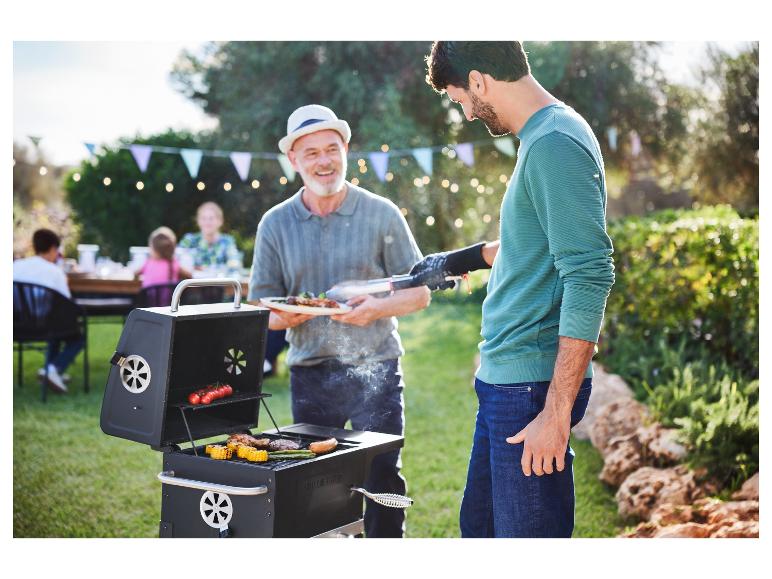 Un homme sert de la viande grillée d'un barbecue Weber.