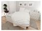 Moderne slaapkamer met wit bed, nachtkastjes, ladekast en decoraties op een houten vloer.
