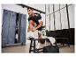 Homme en tenue de sport noire et blanche, mettant des chaussettes dans un vestiaire.