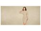 Une femme porte une robe en tricot beige.