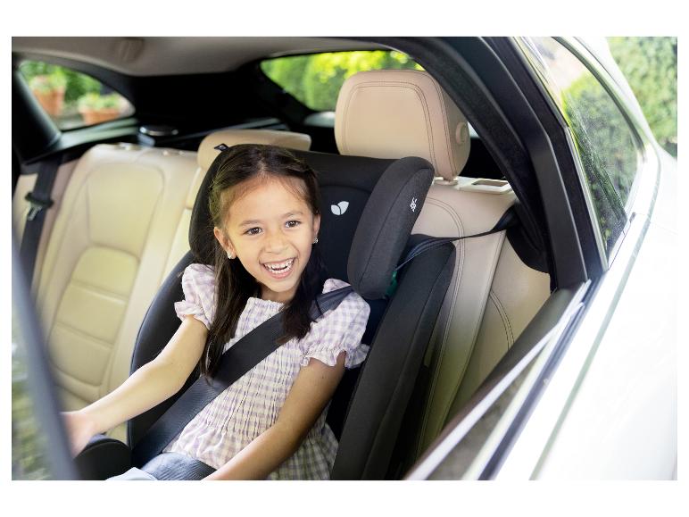 Fille souriante dans un siège auto pour enfant sur la banquette arrière d'une voiture.