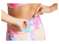 Une femme montre la poche de son legging rose et bleu.