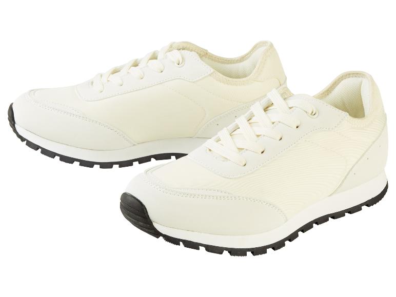 Twee paar witte sneakers met zwarte zolen.