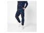 Man in een donkerblauwe kersthoodie en joggingbroek met witte sneakers.