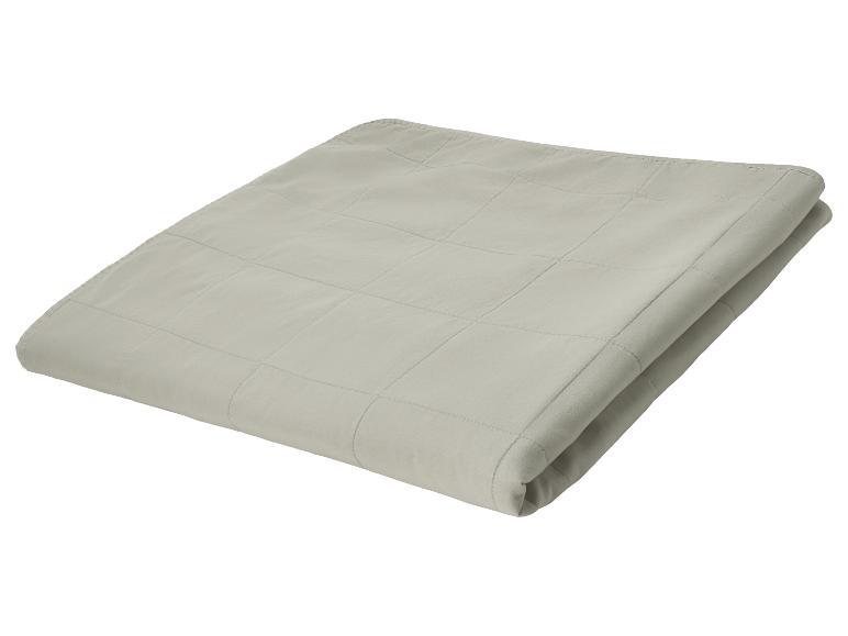 Couverture lestée grise pliée avec motif matelassé.