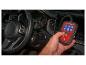 Hand die een Ultimate Speed auto-diagnosetool vasthoudt in een auto