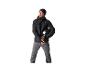 Homme en veste d'hiver Crivit noire et pantalon gris tenant un casque de ski.
