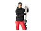 Vrouw in zwarte jas en rode broek, met witte ski's.