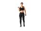 Vrouw in zwarte sportkleding met dumbbells.
