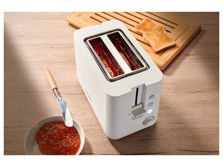 Een witte Cuisinart broodrooster met geroosterd brood en jam.