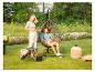 Couple se détendant dans un jardin avec un fauteuil suspendu, une table d'appoint et un éclairage extérieur.