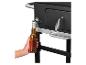 Zwarte barbecue met ingebouwde flesopener en bier.