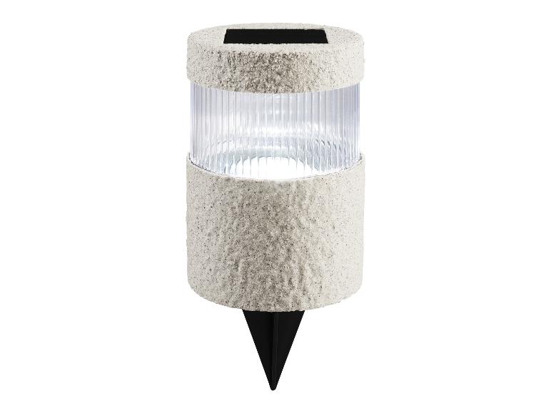 Spot solaire LED à planter avec boîtier transparent nervuré et texture couleur sable.