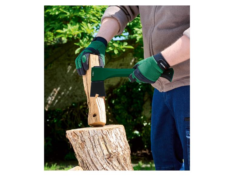 Een persoon met groene handschoenen splijt hout met een Parkside bijl.