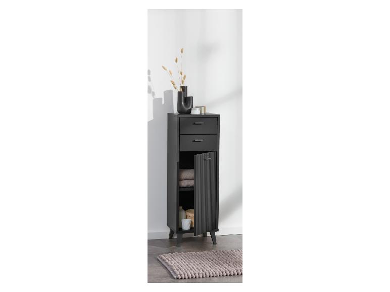Meuble de salle de bain noir avec tiroirs et compartiments, décoré d'un vase et de plantes séchées.
