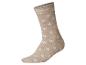 Chaussette beige avec des motifs de flocons de neige blancs.