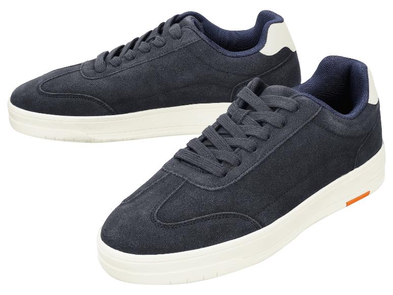 Twee marineblauwe suède casual sneakers met witte zolen.