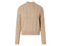 Pull en tricot beige à motif torsadé.