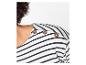 Close-up van een vrouw in een wit-zwart gestreepte top met decoratieve knopen op de schouder.