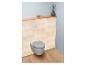 Toilettes suspendues avec abattant gris, lambris en bois et étagère en bois clair.