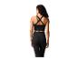 Femme en brassière de sport noire à dos croisé et leggings noirs, vue arrière.