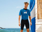 Man in een blauw Mares wetsuit met een surfplank.