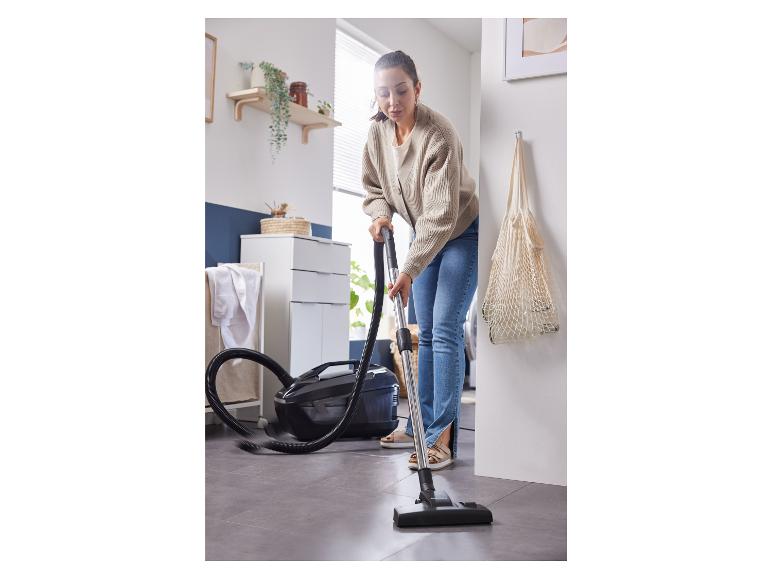 Een vrouw gebruikt een stofzuiger van het merk Bosch om haar vloer te reinigen.
