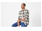 Homme en chemise à carreaux, t-shirt beige et jean.