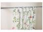Gordijnen met een bloemenprint hangen aan een gordijnroede.