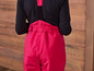 Een close-up van de achterkant van een roze overall met bretels.