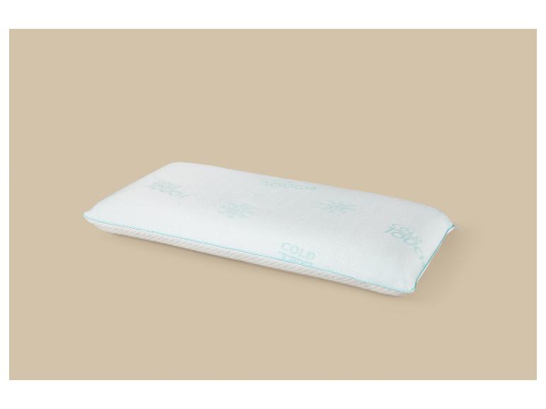 Oreiller blanc avec l'inscription «COLD TOUCH» et un liseré bleu sur fond beige.