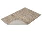 Beige badmat met een opstaande rand die de antislip onderkant toont.